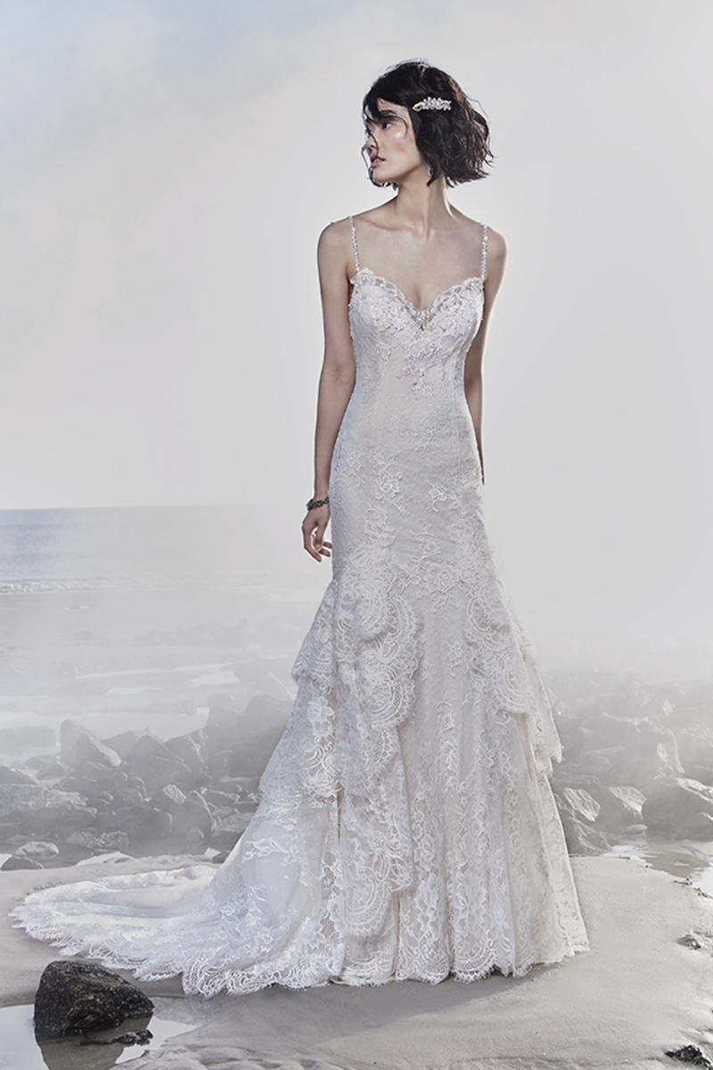 Este vestido de noiva sexy apresenta rendas extremamente românticas que aceituam a silhueta e curvas da noiva, conferindo uma textura única à saia de fit-and-flare em camadas. Alças finas frisadas completam o decote de ilusão e as costas também em ilusão, ambos acentuados em motivos de rendas. Termina com botões de cristal que cobrem o fecho.
<a href="https://www.maggiesottero.com/sottero-and-midgley/jackson/11542">Sottero and Midgley</a>
